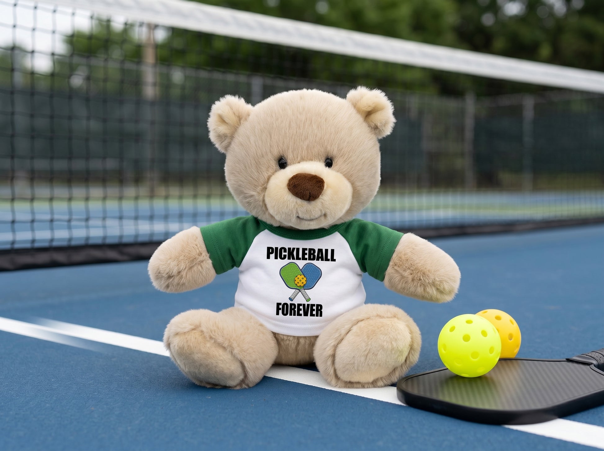 Personalized Pickleball Teddy Bear - 10" Tan Nuzzles Bear, Paddle Design - Green sleeved shirt, pictured on pickleball court. Perfect gift for pickleball enthusiasts.